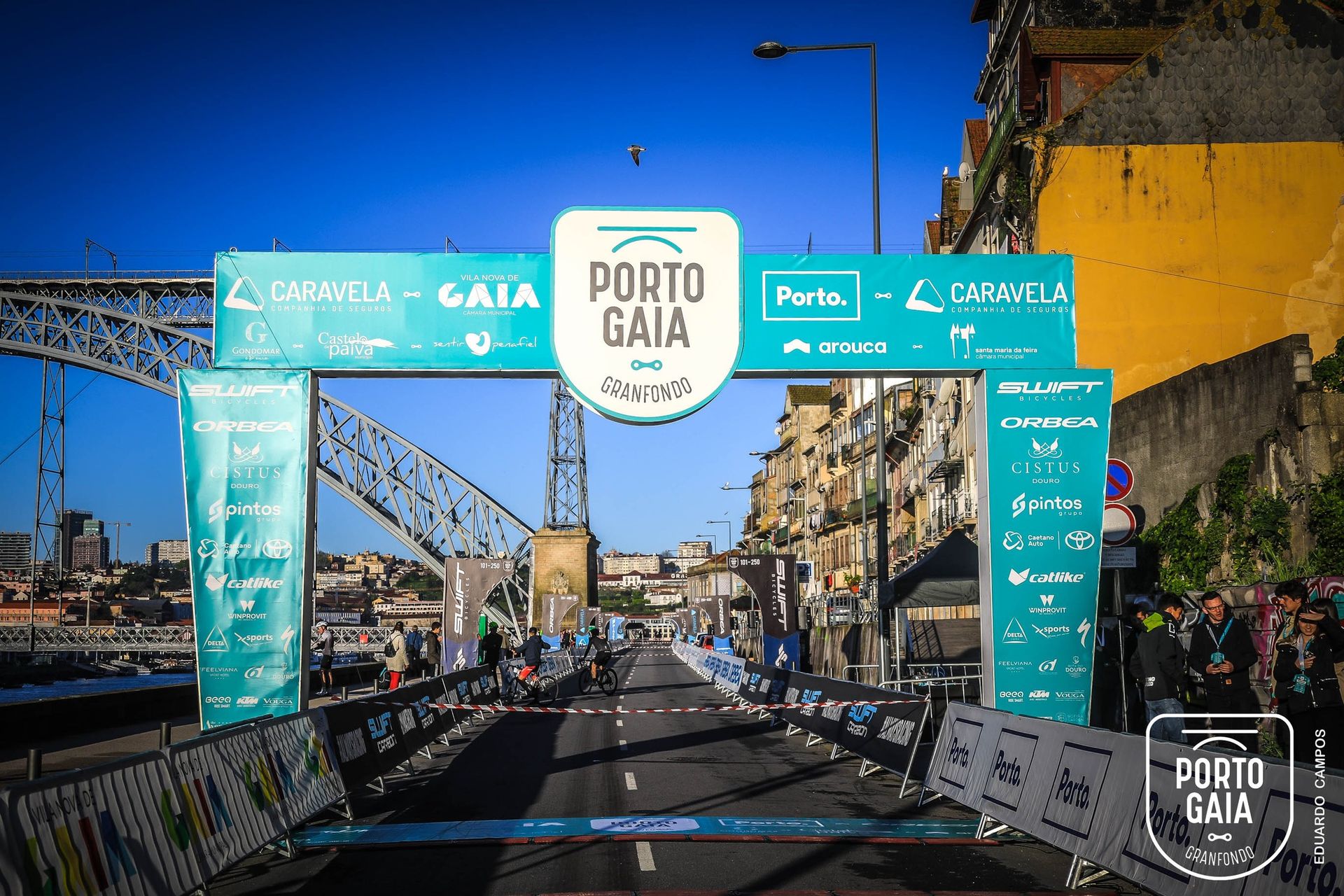 Ciclistas no Porto Gaia Granfondo 2024 ao amanhecer
